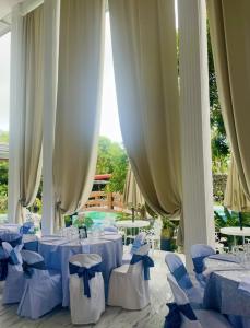 ein Esszimmer mit Tischen, Stühlen und Vorhängen in der Unterkunft I Love Villa Victoria Resort in Victoria