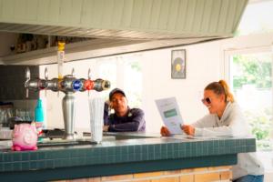 a man and woman sitting at a counter in a kitchen at Ushuaïa Villages-Domaine de Scott in Montigny-en-Morvan +50 photos