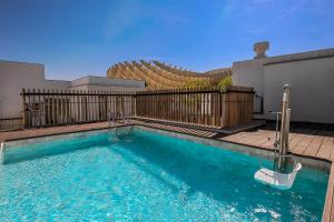 een zwembad op een huis met een hek bij Intelier Casa de Indias in Sevilla