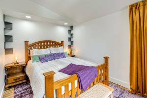 a bedroom with a wooden bed with purple pillows at Walk to Beach Historic Downtown Anacortes Studio in Anacortes