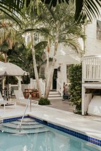 a house with a swimming pool and palm trees at Ridley House - Key West Historic Inns in Key West