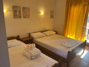 two beds in a room with towels on them at Hotel Kosmas in Sarti
