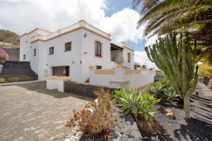 a white house with a palm tree in front of it at Finca Bellavista in Teguise