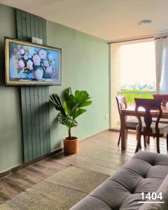 a living room with a table and a painting on the wall at Apartamento en Armenia - Edificio Mediterráneo - Con Piscina - By Molca Travel in Armenia