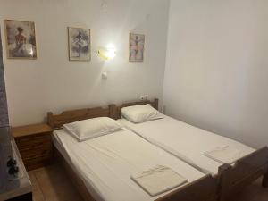 a small bedroom with two beds with white sheets at Hotel Kosmas in Sarti