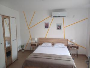 a bedroom with a large bed with yellow lines on the wall at Kućica LaMa-Кућица ЛаМа in Mali Mokri Lug