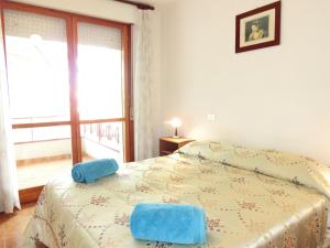 Un dormitorio con una cama con toallas azules. en freepark relax and sea Pool & free wifi & AC, en Lignano Sabbiadoro