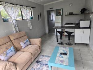 a living room with a couch and a table at Cozy Cottage in Hermanus +12 photos