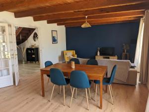 comedor con mesa de madera y sillas azules en l'Echappee belle Seaside break for 8 people, en Plougasnou 27 fotos más