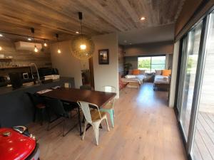 a dining room and living room with a table and chairs at 自然と調和するデザイン空間に癒される宿,田園風景,焚火,BBQ,宿M-Kagu in Isumi