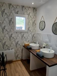 a bathroom with two sinks on a wooden counter at Les Oliviers in Chériennes