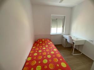 a small white room with a bed and a desk at Beachside Getaway in Zapillo in Almería