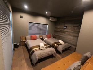 a room with three beds and a couch at 自然と調和するデザイン空間に癒される宿,田園風景,焚火,BBQ,宿M-Kagu in Isumi