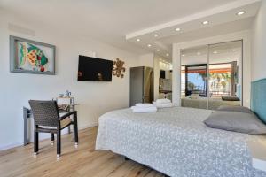 Un dormitorio con una cama, un escritorio y un espejo. en Sunset Tenerife, en Playa de las Américas 30 fotos más