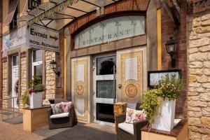 a store front with chairs in front of a building at La Maison ERNENWEIN in Obermodern