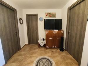 a living room with a flat screen tv and two doors at Jenny's House in Yerakiní