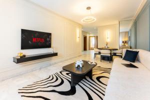 The Loft Residence by GoodMove - Maarif Casablanca في الدار البيضاء: غرفة معيشة مع أريكة وتلفزيون