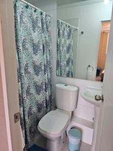 a bathroom with a toilet and a sink and a mirror at Departamento en condominio a 10min del centro in Puerto Montt