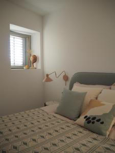 a bedroom with a bed and a lamp and a window at mi sestre – Studio Apartment Hvar Vrisnik in Jelsa