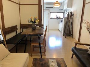 a living room with a table with a vase of flowers on it at Nostalgic townscape KISHINOSATO in Osaka
