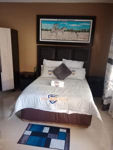 a bedroom with a bed with a poster of zebras at MC One Stop Road Lounge Hotel in Xai-Xai +17 photos