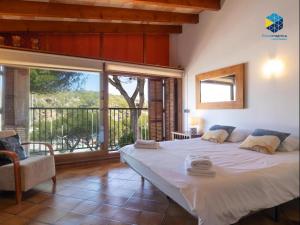 a bedroom with a large bed and a large window at The Old Fisherman House in Cala Figuera