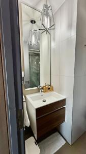 un bagno con lavandino e specchio di Cerati Apartment frente al metro Irarrazaval a El Cerrillo