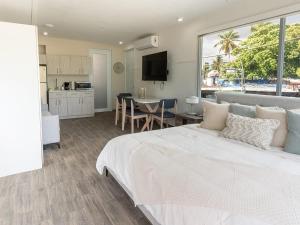 una camera con un grande letto bianco e una cucina di AQUA Terrazas Studio 7 - Beachfront Getaway with King Bed & Pool a Dorado Altre 13 foto