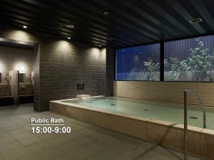 a large swimming pool in a building with a large window at Mitsui Garden Hotel Kyoto Shinmachi Bettei in Kyoto