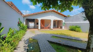 una casa con una hamaca fuera de ella en Casa Temporada Ubatuba próxima à praia, check-in e out flexíveis com 5 vagas na garagem, wifi, en Ubatuba