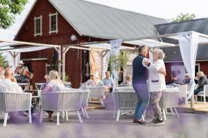 a man and woman hugging in front of a building at Toftagården Bed and Breakfast in Gottland