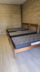 2 letti posti in una stanza con parete di Chácara Recanto dos Pássaros 04 a Olímpia