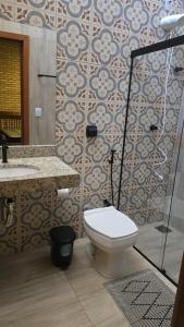 un bagno con wc, lavandino e doccia di Chácara Recanto dos Pássaros 04 a Olímpia