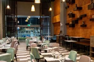 a dining room with tables and chairs and windows at Tierra Viva Tacna in Tacna