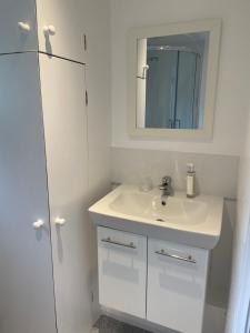 a white bathroom with a sink and a mirror at The Batch in Thorverton