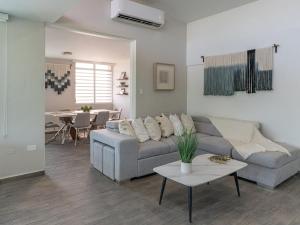 un soggiorno con un divano e un tavolo di AQUA Terrazas Apt 6 - Beachfront Gem with Ocean Views & Pool a Dorado Altre 25 foto