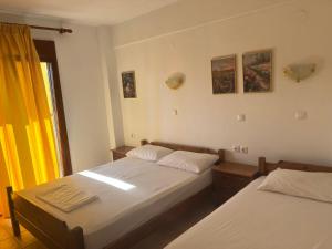 a bedroom with two beds and a window at Hotel Kosmas in Sarti