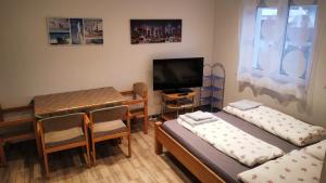 ein Zimmer mit zwei Betten und einem Tisch und einem Fernseher in der Unterkunft Monteurzimmer mit Singleküche in Kaufing