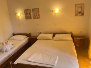two beds in a room with lights on the wall at Hotel Kosmas in Sarti
