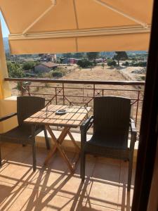 a table and chairs on a balcony with an umbrella at Hotel Kosmas in Sarti