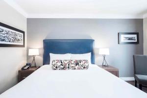 una camera con un letto con un testata blu e due lampade di Sandman Signature Prince George Hotel a Prince George Altre 56 foto