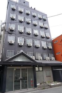 a building with air conditioners on the side of it at 心斎橋難波関空直通Sakurabarsh Ryokan Ambers Hostel in Osaka