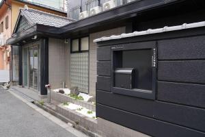 a black building with a mailbox on the side of it at 心斎橋難波関空直通Sakurabarsh Ryokan Ambers Hostel in Osaka