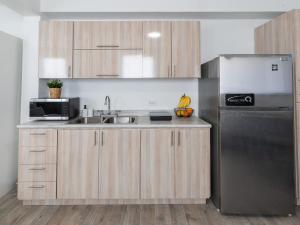 a kitchen with a sink and a refrigerator at AQUA Terrazas Studio 1 - ADA Accessible - Beach, Pool & Dining in Dorado +11 photos