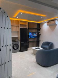 a living room with a blue chair and a kitchen at Bungalow amsa in Amsal +19 photos