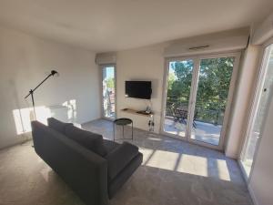 a living room with a couch and a tv at Appartement Moderne & Proche Commodités in Toulouse
