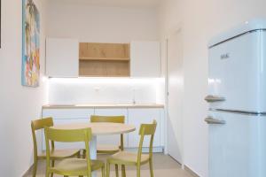 a kitchen with a table and chairs and a refrigerator at Fontanelle Seaside in Fontanelle