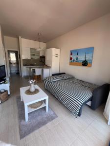 a living room with two beds and a table at Taurito Bay in Taurito +65 photos