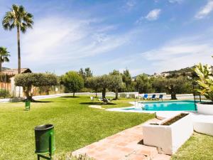 un ampio cortile con piscina e prato di Apartamento Luminoso Marbella a Marbella
