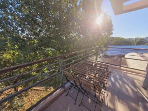 a bench sitting on a balcony with the sun shining at Appartement Moderne & Proche Commodités in Toulouse